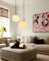 Stockholm Pendel Ø30 Marmorbrun fra Halo Design i en stue ved en sofa - blødt lys og ro ved sofaen