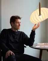 DC Textile Pendel Satinhvid fra Halo Design på et lille bord i en stue - blødt lys ved læsning